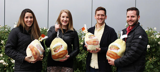 Nu Skin employees posing for a picture holding turkeys for Thanksgiving